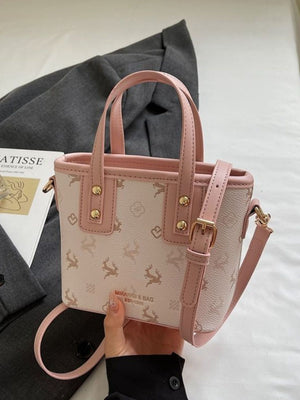 Charming mini crossbody bag in blush pink with a deer print and gold hardware.