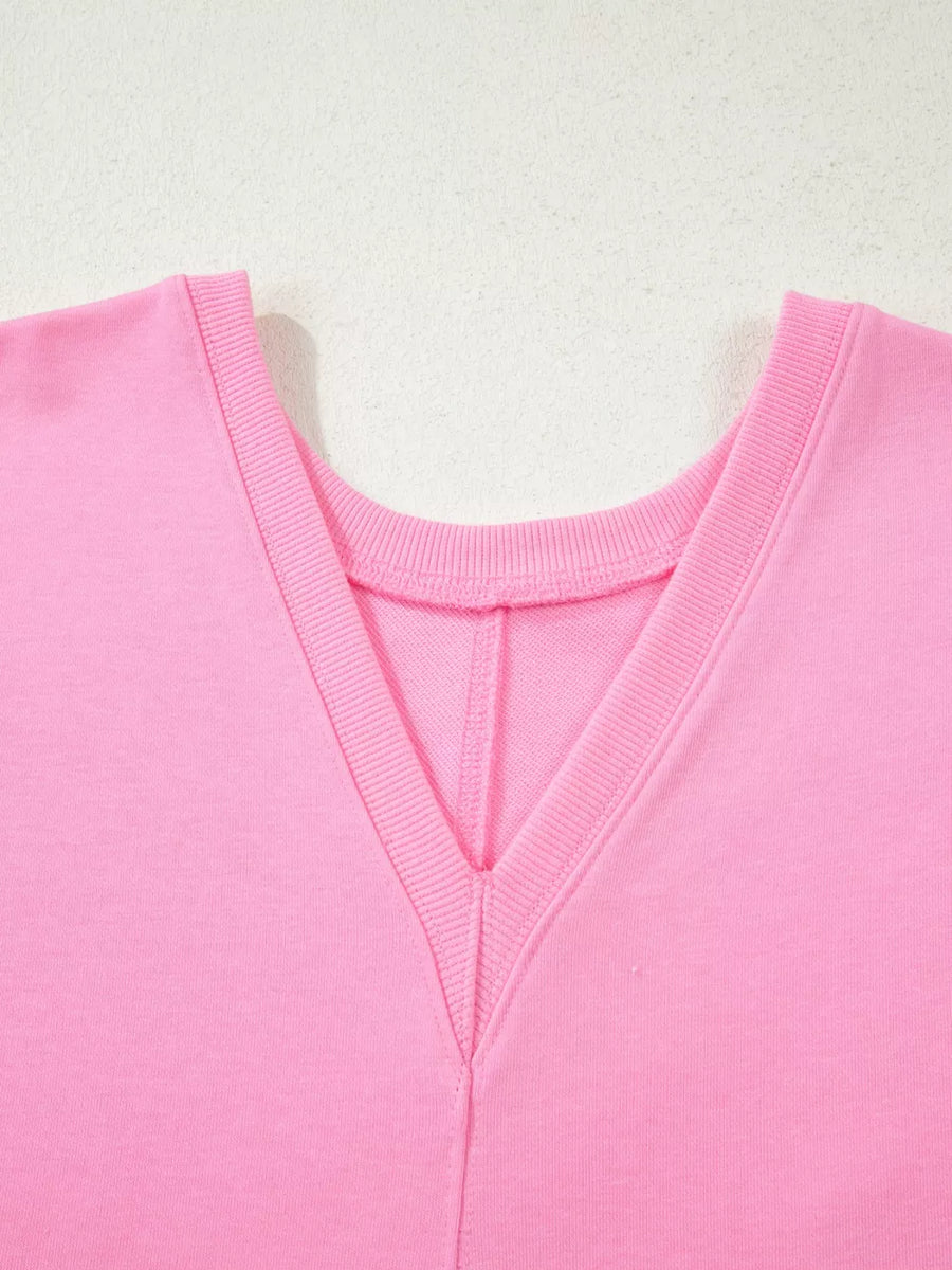 Pink cotton romper with V-neck and ribbed trim detail