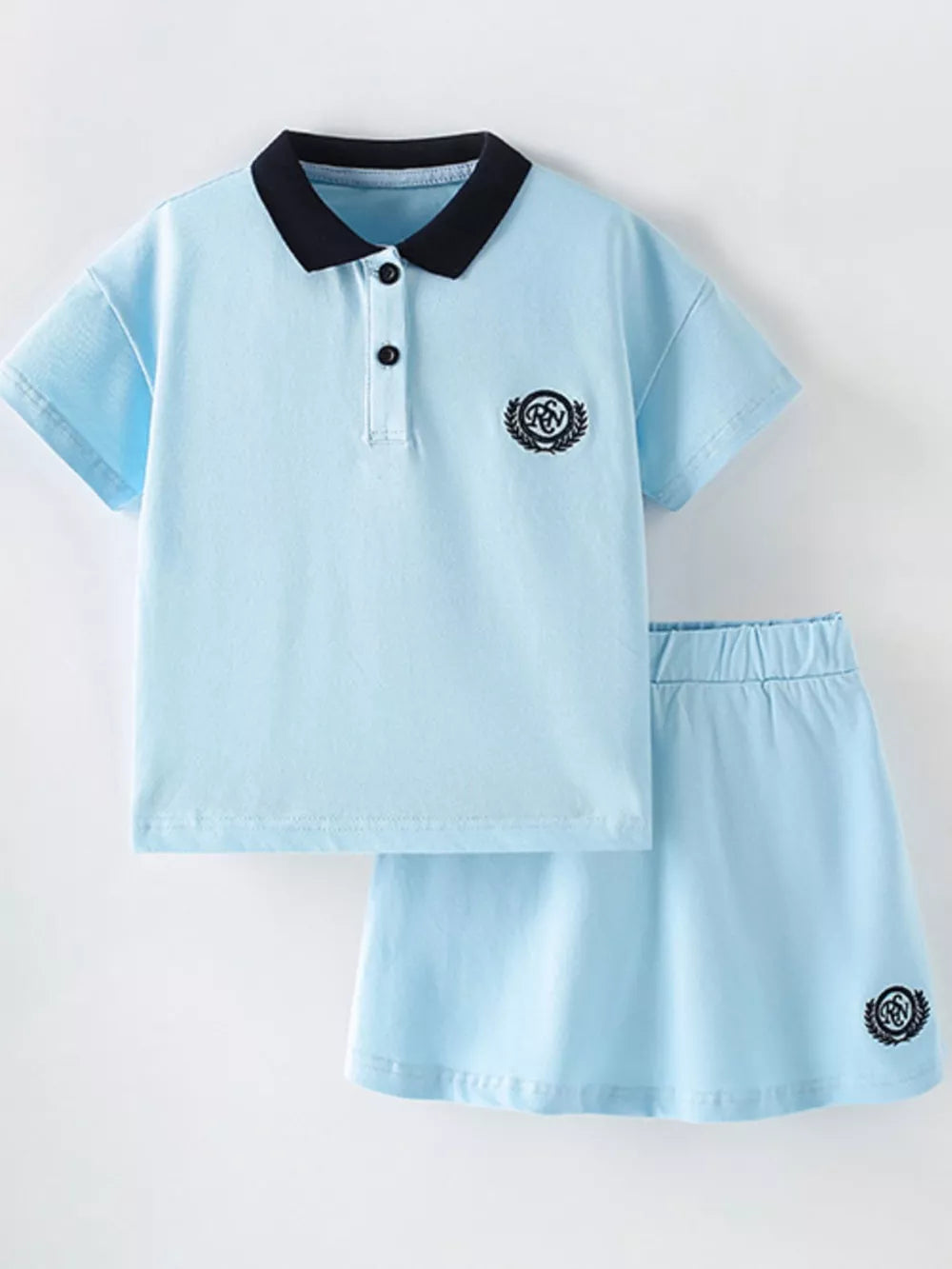 Light blue cotton polo shirt and a-line skort set with navy collar and embroidered crests.