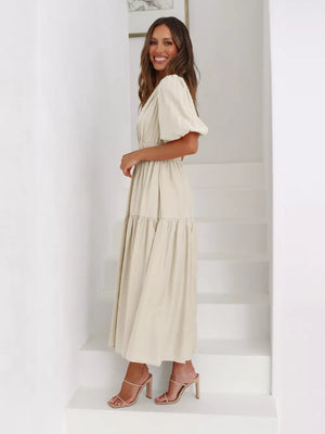 Beige midi dress with puff sleeves, V-neck, and tiered skirt.