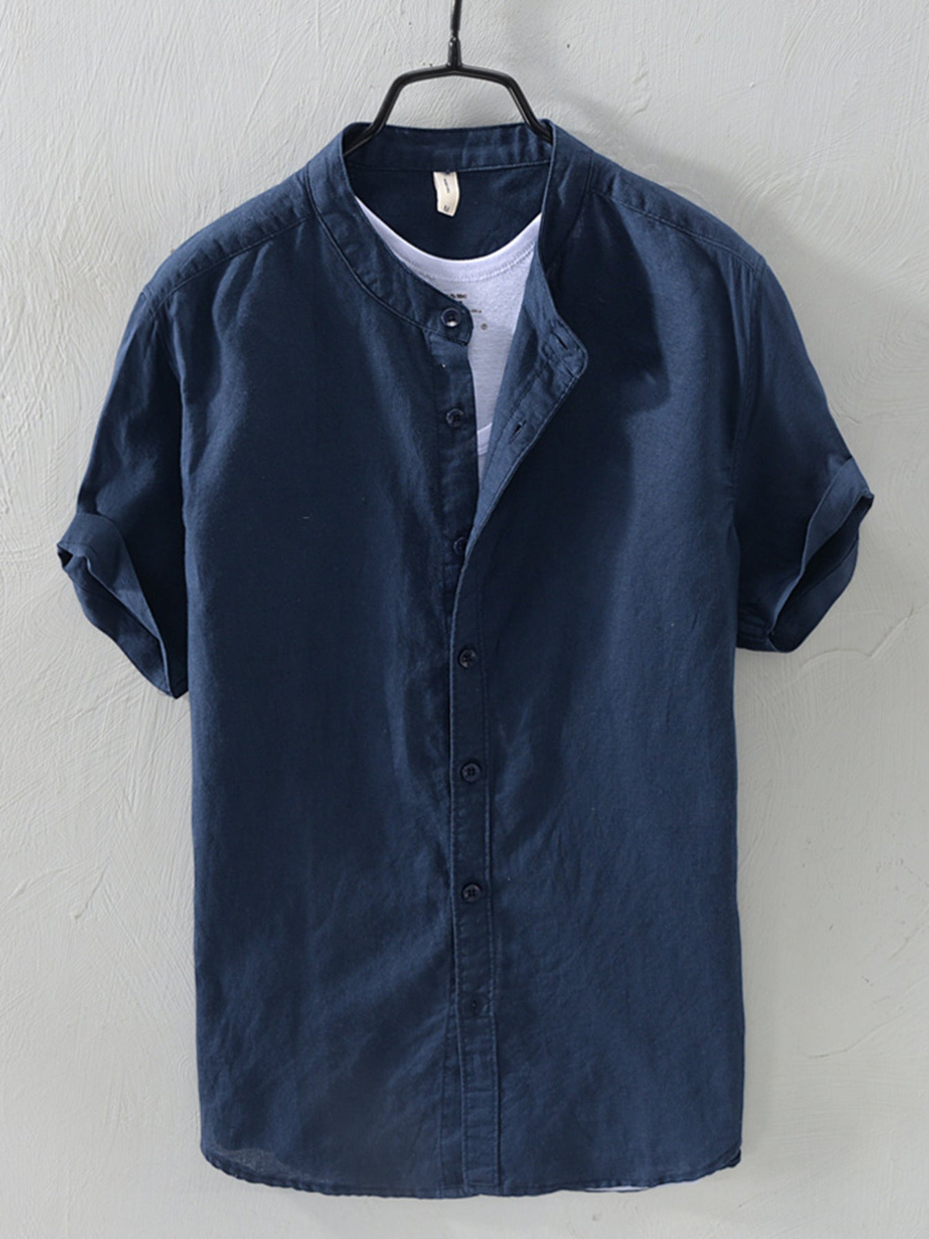 Navy blue linen short sleeve band collar shirt with rolled cuffs.