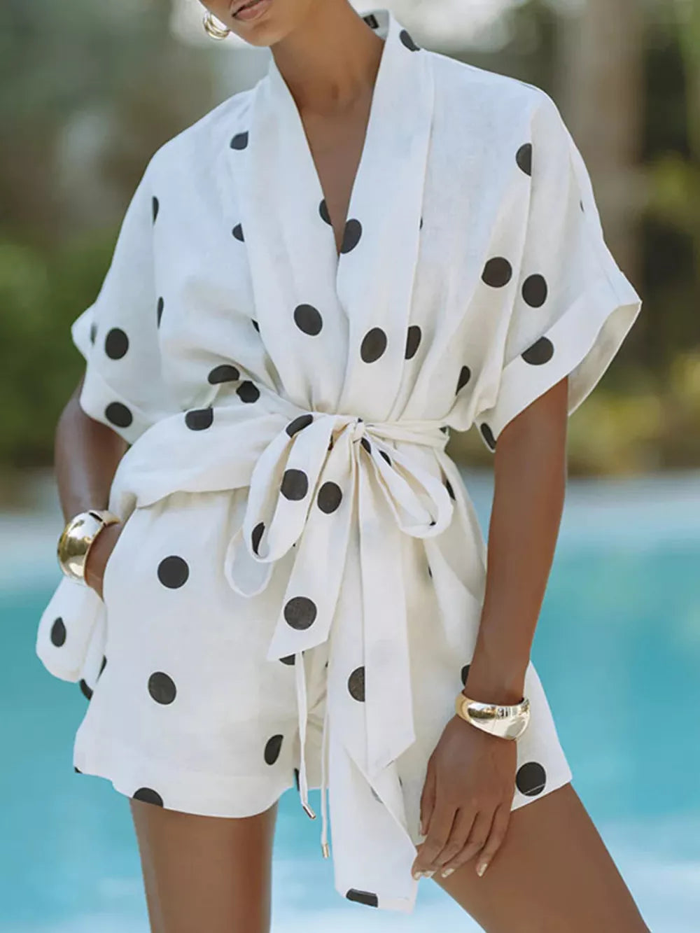 Chic polka dot tie-waist two-piece set with cuffed sleeves and shorts.
