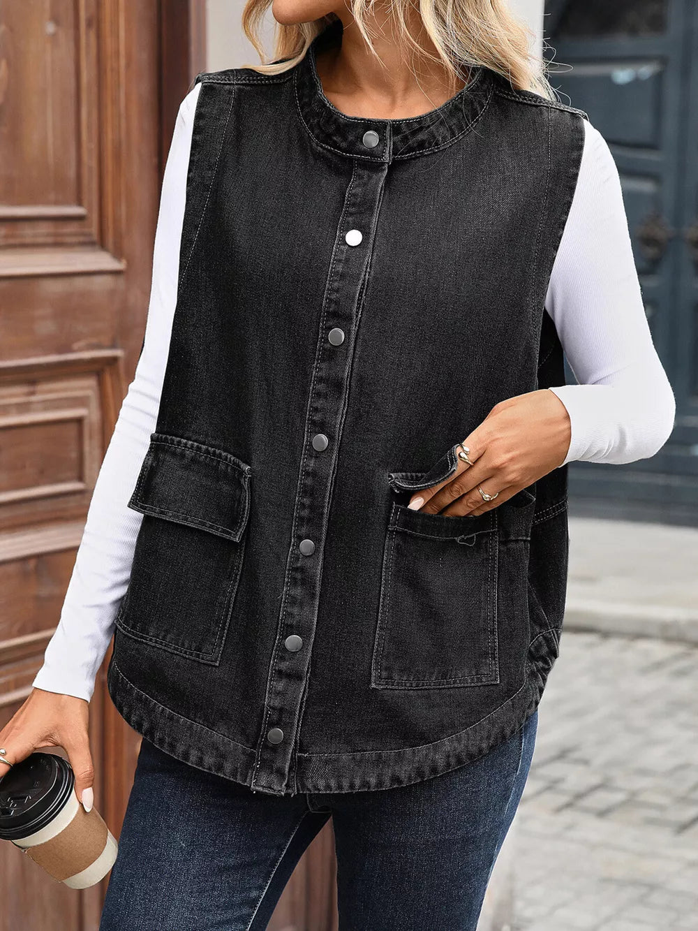 Black sleeveless denim vest with band collar and button front, featuring chest pockets.