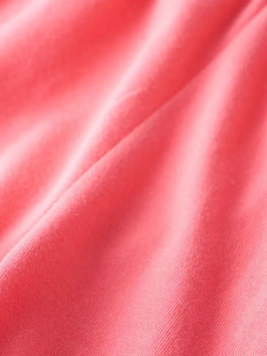 Coral pink ribbed knit fabric with soft texture and subtle sheen.