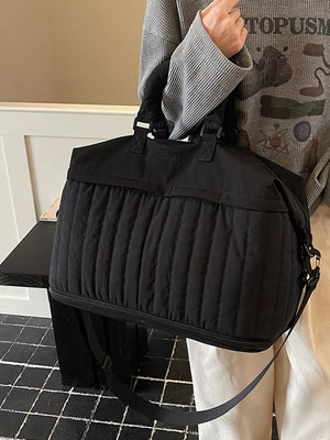 Chic quilted nylon travel bag in black with adjustable strap and top handles.