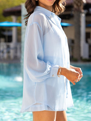 Light blue sheer button-down shirt with cuffed sleeves and matching shorts, styled with bracelets.