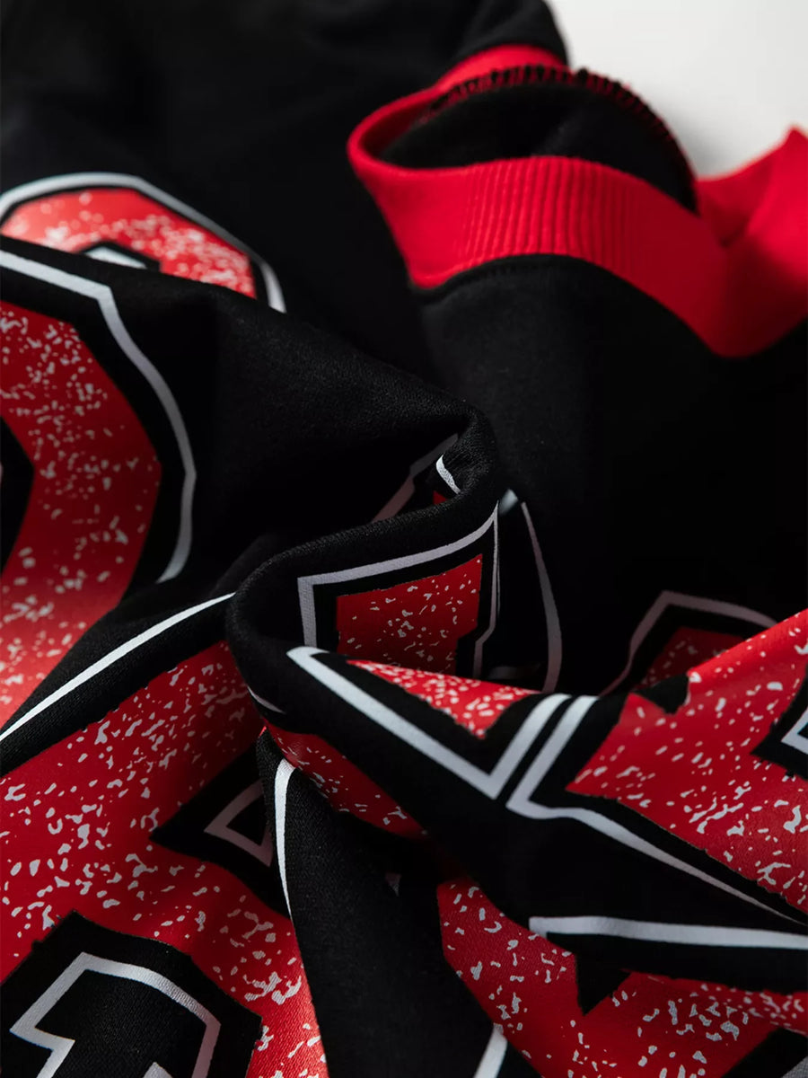 Black sweatshirt with red and white varsity graphic detail and red ribbed cuffs.