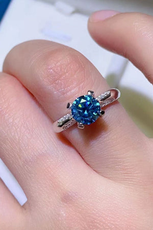 Celestial blue moissanite engagement ring with diamond accents on a silver band.