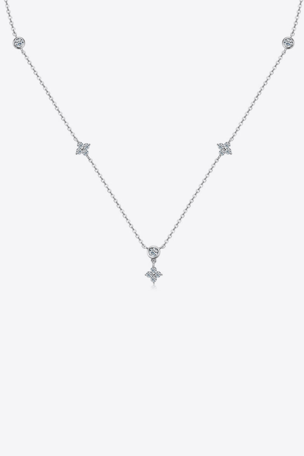 Silver diamond cluster necklace with delicate chain and four-petal flower charms.