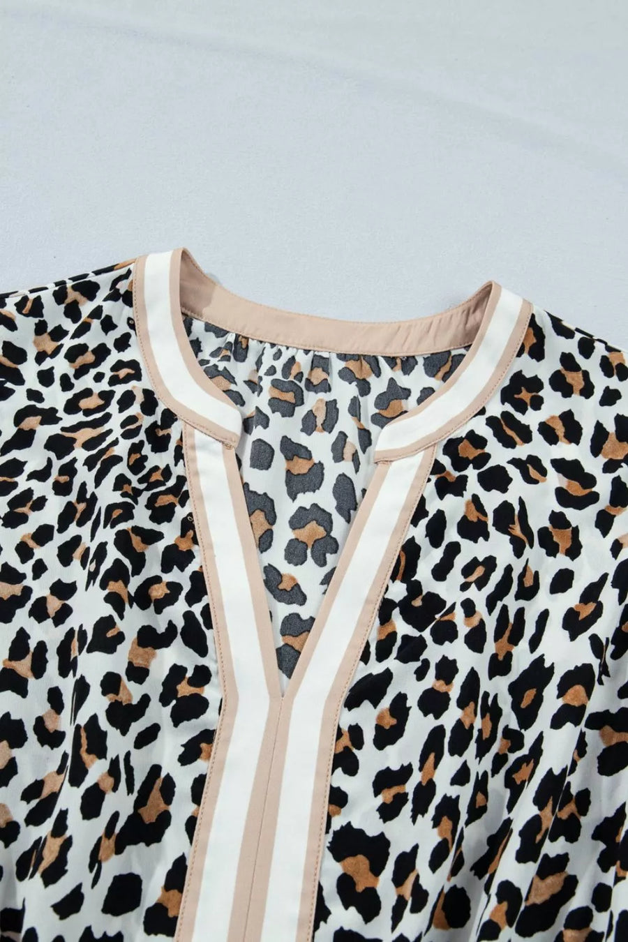 Leopard print midi dress with V-neck and colorblock trim detail.