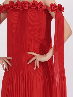 Red off-shoulder maxi dress with floral applique neckline and pleated fabric.
