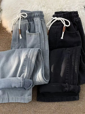 Men's wide-leg jeans in black and blue with drawstring waist and side stripe detail.