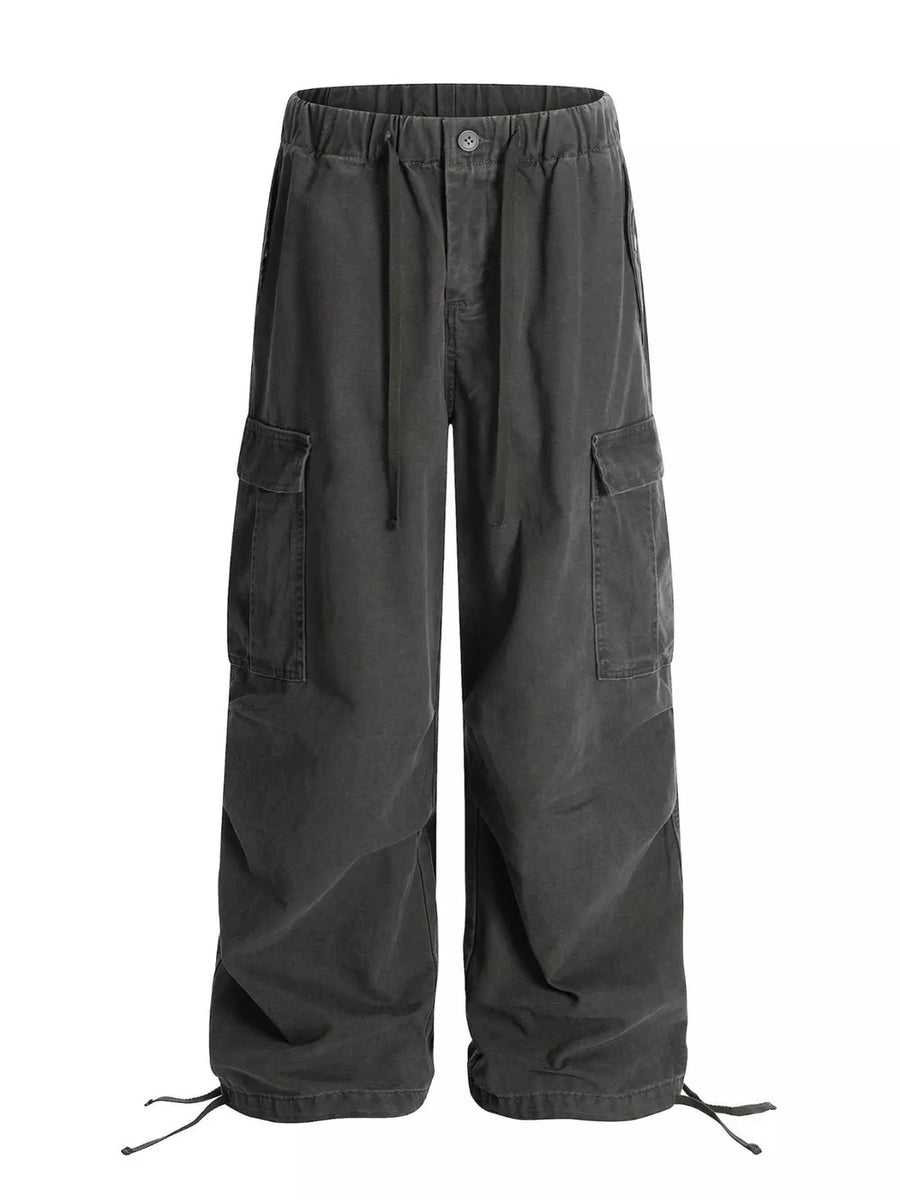 Grey cargo pants with adjustable drawstring waist and hem, featuring multiple pockets.
