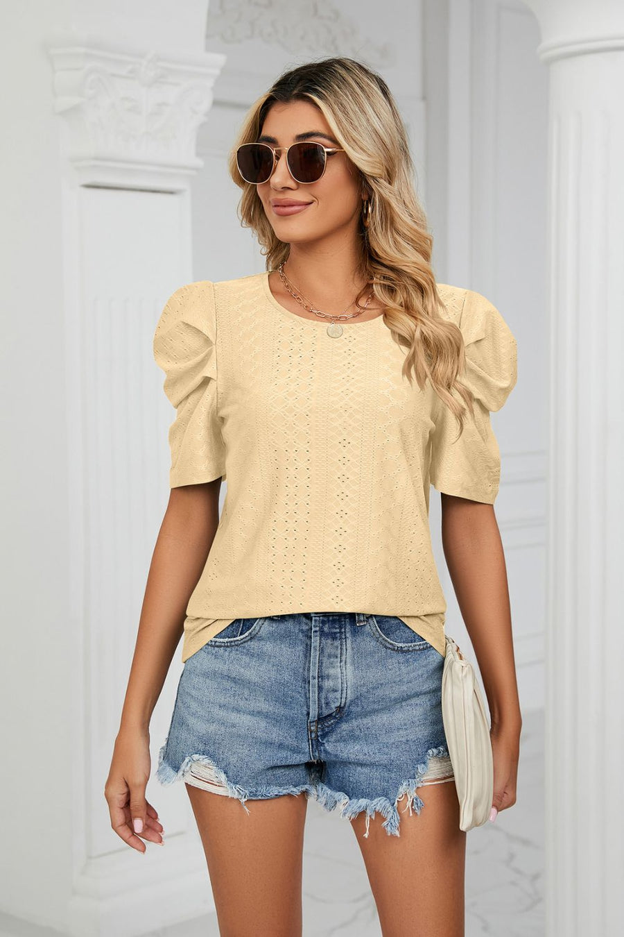 Yellow perforated sleeve volume blouse with round neckline and puff sleeves.