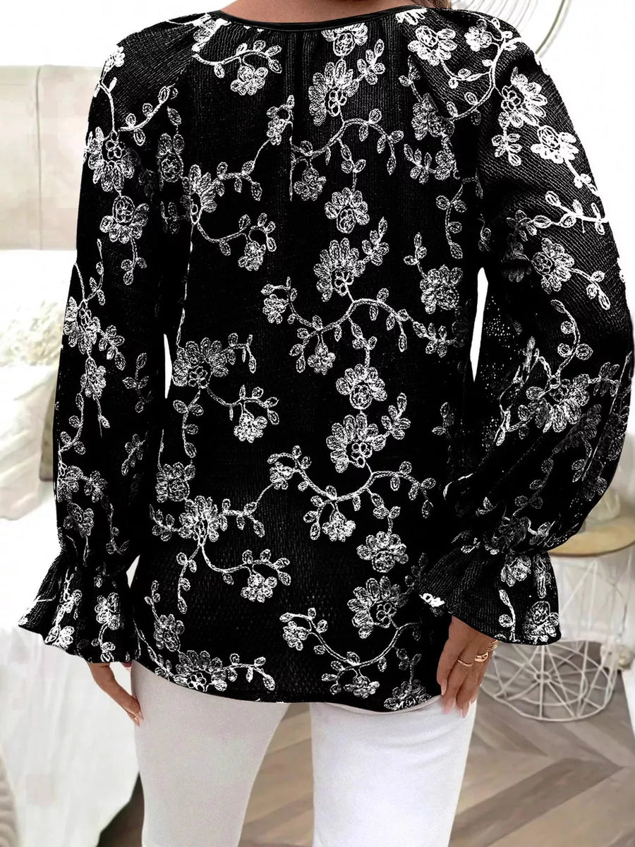 Black embroidered sheer long-sleeve blouse with ruffled cuffs.