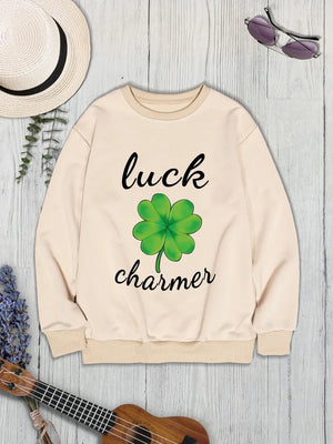 Khaki graphic sweatshirt with a green four-leaf clover and "luck charmer" text.