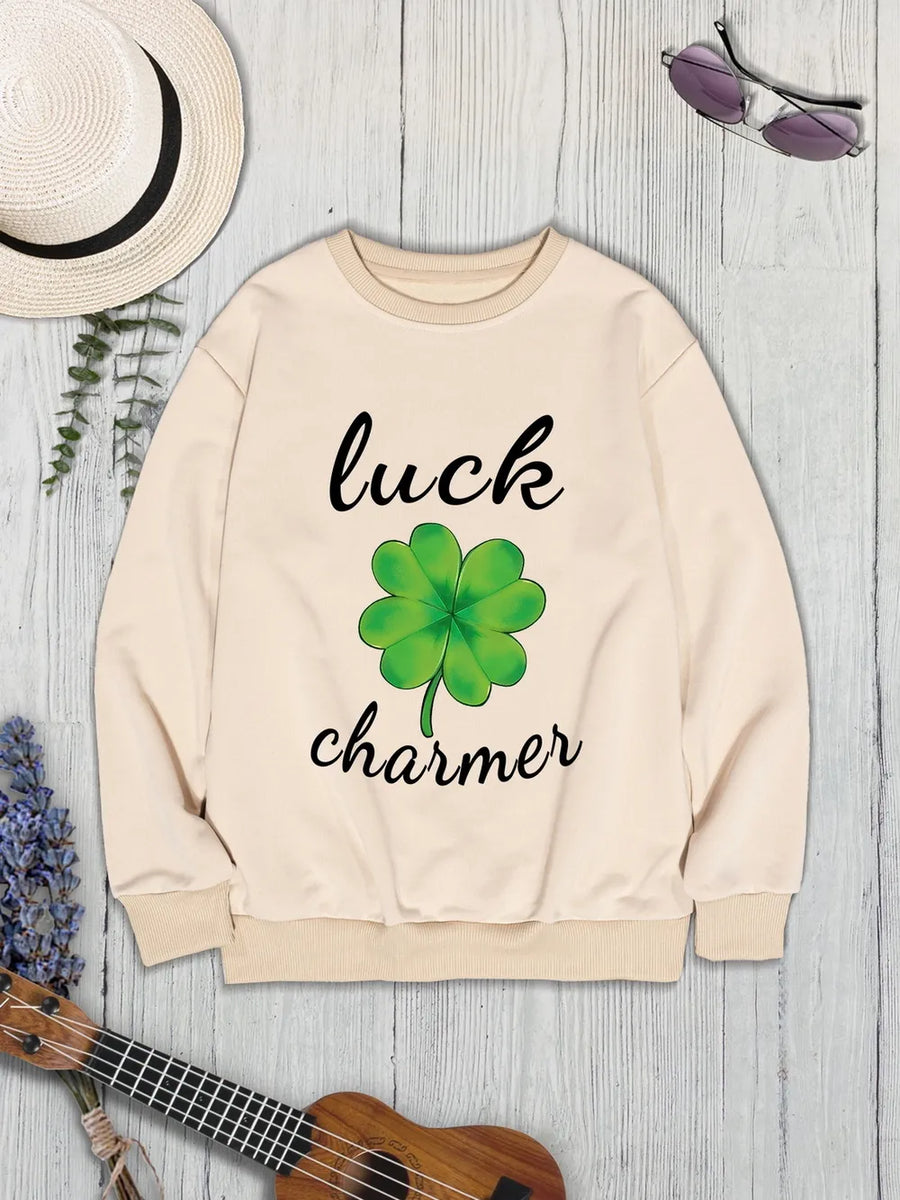 Khaki graphic sweatshirt with a green four-leaf clover and "luck charmer" text.