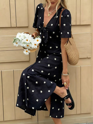 Navy blue daisy print midi dress with tie-front and short sleeves.
