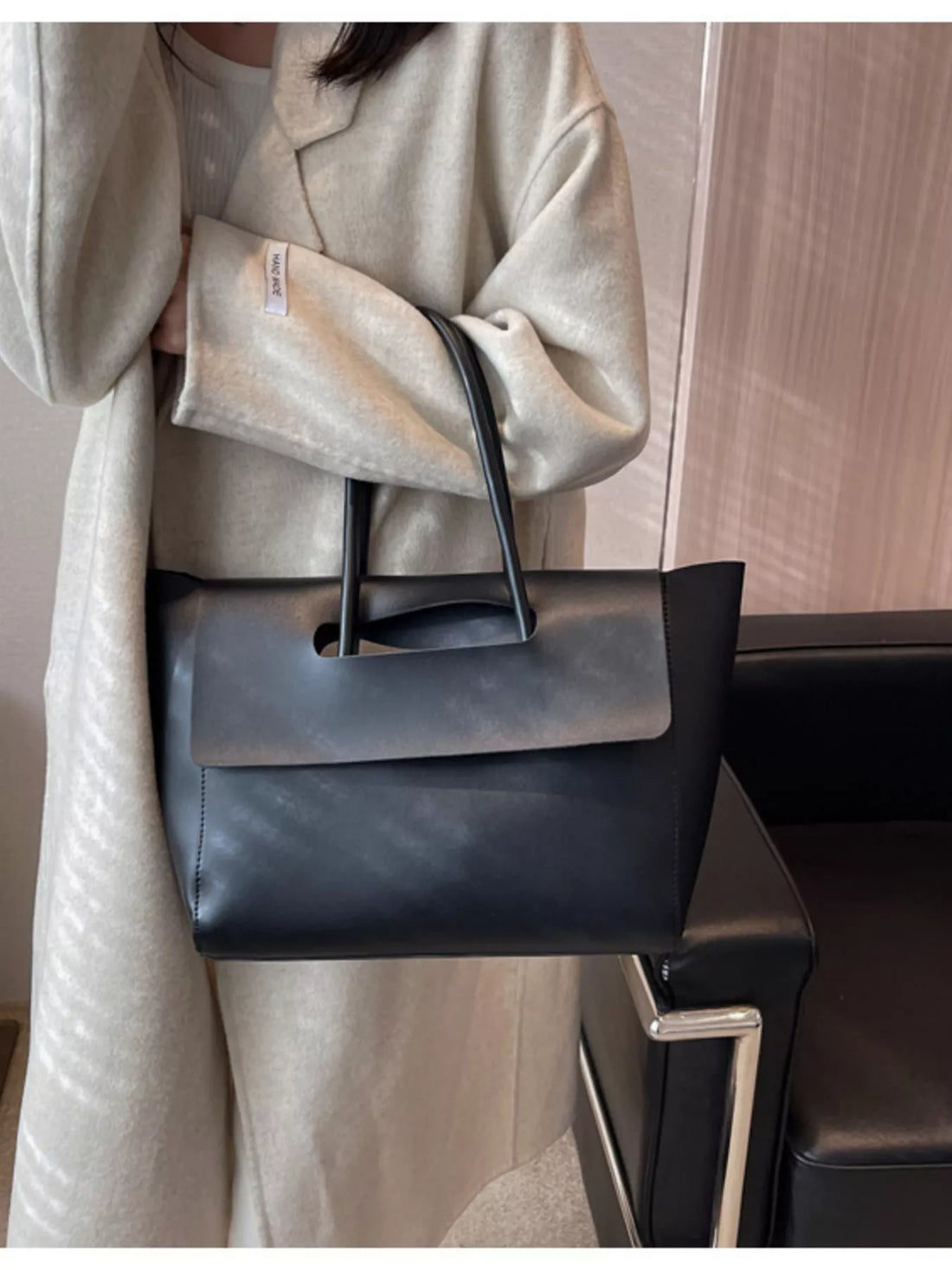 Sleek black PU leather tote shopper bag with cutout handle detail.