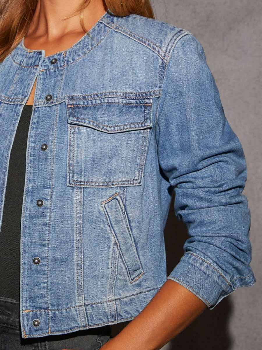 Light wash denim utility jacket with band collar, chest pocket, and button front.