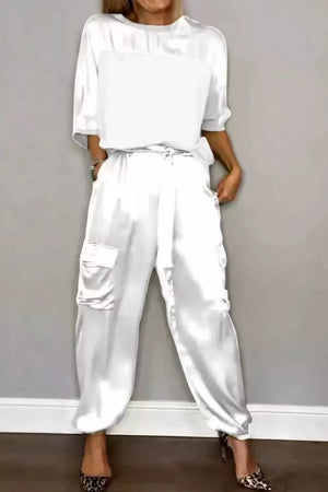 White satin two-piece set with crew neck top and cargo pants, featuring a drawstring waist.