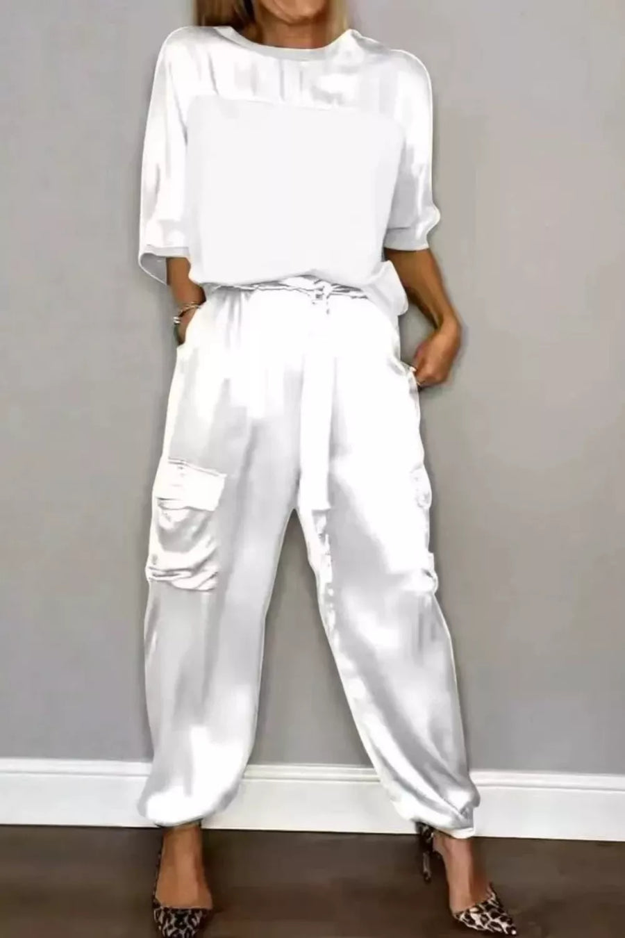 White satin two-piece set with crew neck top and cargo pants, featuring a drawstring waist.