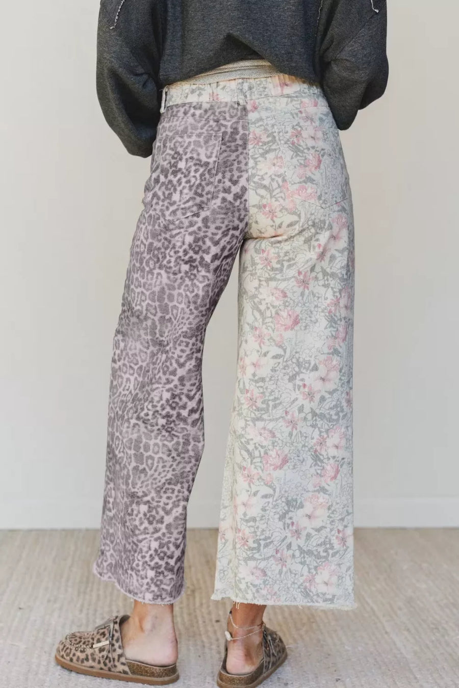 Wide-leg jeans with split floral and leopard print, cropped length, and frayed hem.