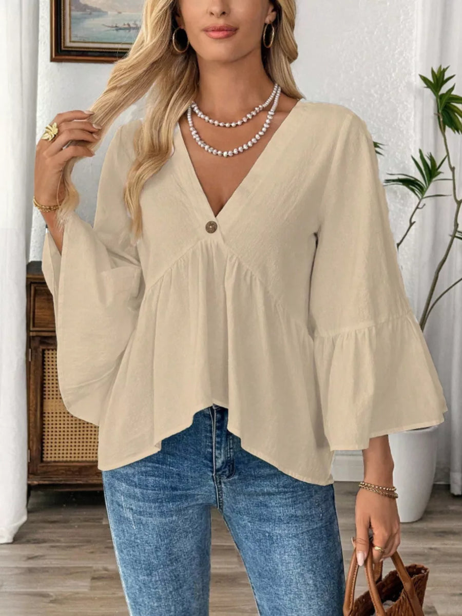Apricot cotton V-neck blouse with bell sleeves and a button detail.