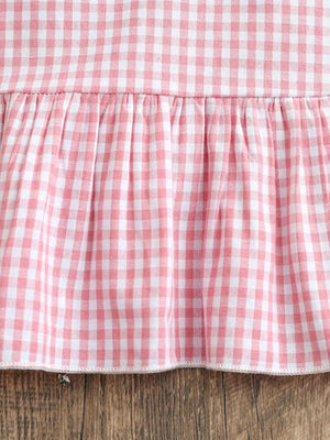 Baby cotton gingham dress in blush pink with a ruffled hem detail.