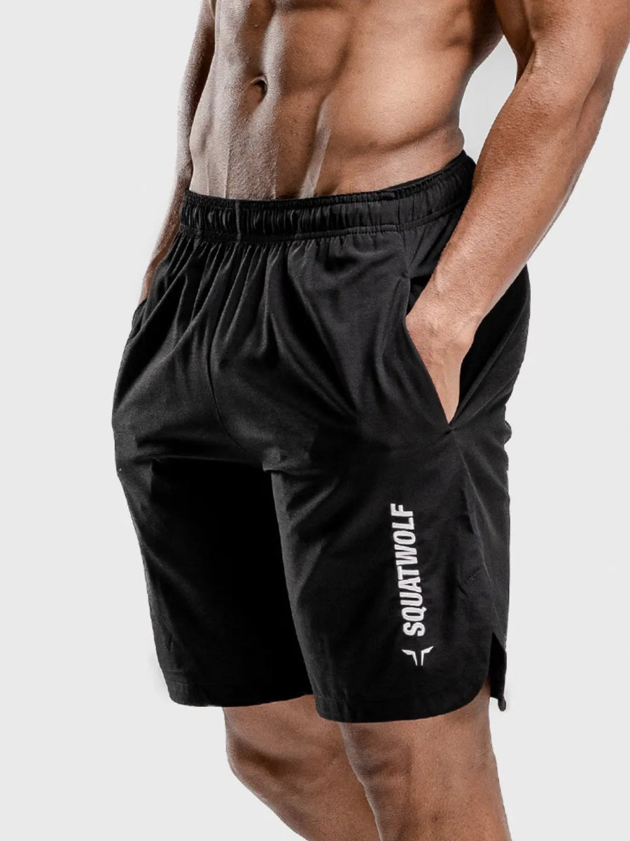 Black performance shorts with split hem and white logo detail, elastic waistband.