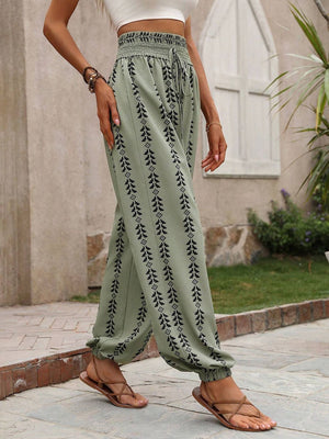 Sage ankle trousers with black leaf print, gathered waist and cuffs.