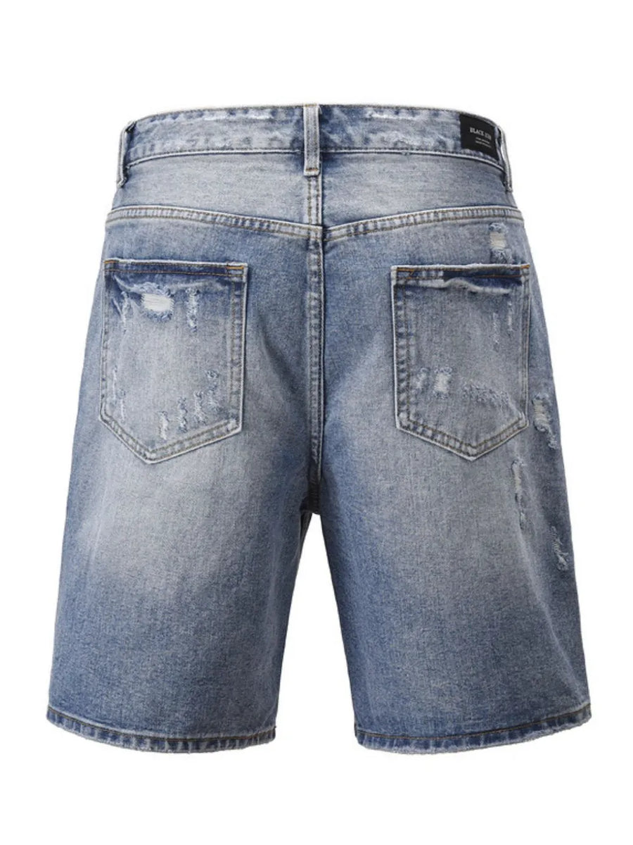 Ripped denim bermuda shorts in medium wash, featuring distressed details and a casual cut.