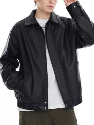 Black faux leather bomber jacket with a collared neckline and elasticized cuffs and hem.