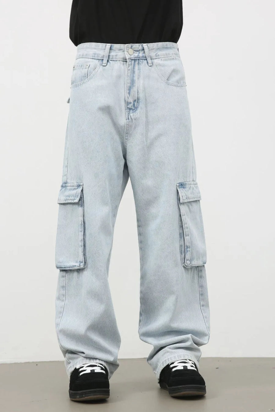 Oversized light wash denim cargo pants with large side pockets and a relaxed fit.