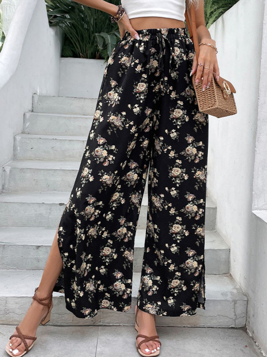 Black floral palazzo trousers with split hems and a drawstring waist.