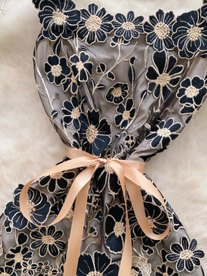 Embroidered floral mini dress in black gold with a satin bow detail.