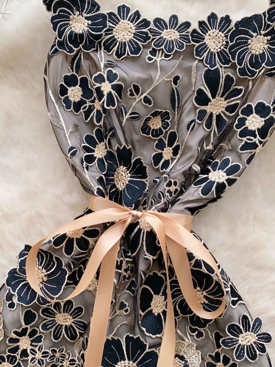 Embroidered floral mini dress in black gold with a satin bow detail.