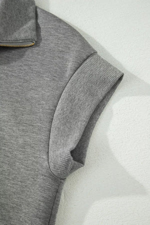 Chic dark gray half-zip polo top with ribbed cuffs and collar detail.