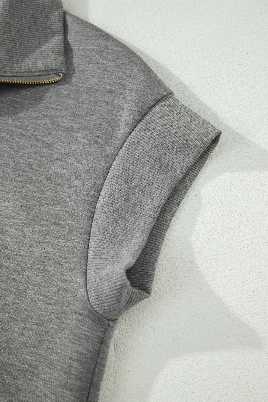 Chic dark gray half-zip polo top with ribbed cuffs and collar detail.