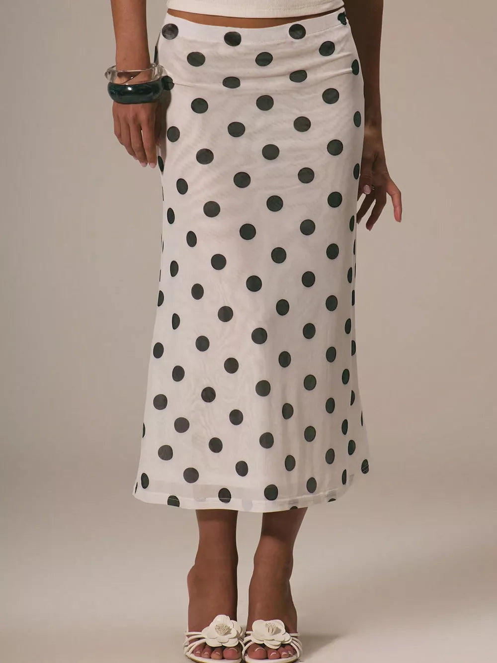 White midi skirt with black polka dots, sheer fabric, and a high waist.