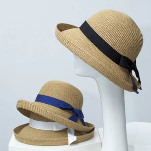 Elegant straw sun hat with black ribbon detail and bow, bell-shaped brim.