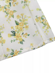 Charming floral mini dress with puff sleeves in white with yellow floral print.