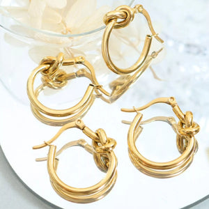 Gold knot hoop earrings with a triple strand design.