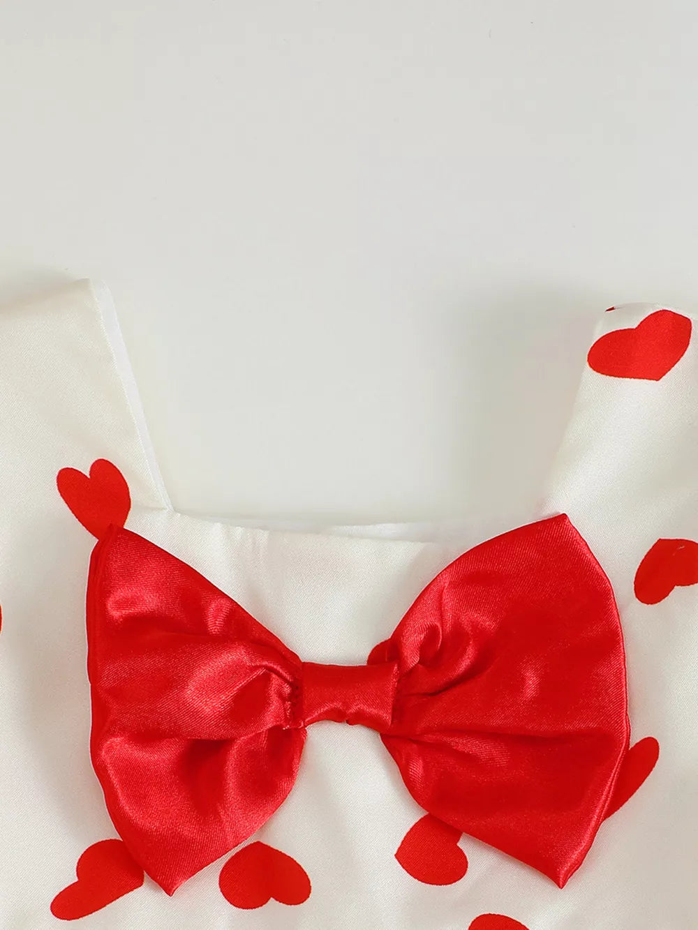 Baby dress with red hearts pattern and satin bow detail