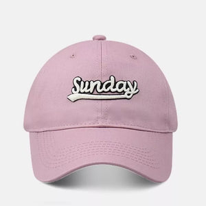 Pink baseball cap with embroidered "Sunday" text and curved brim.