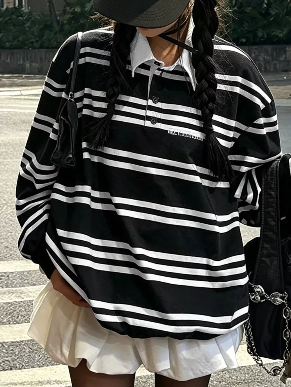 white polo shirt featuring buttoned placket and striped