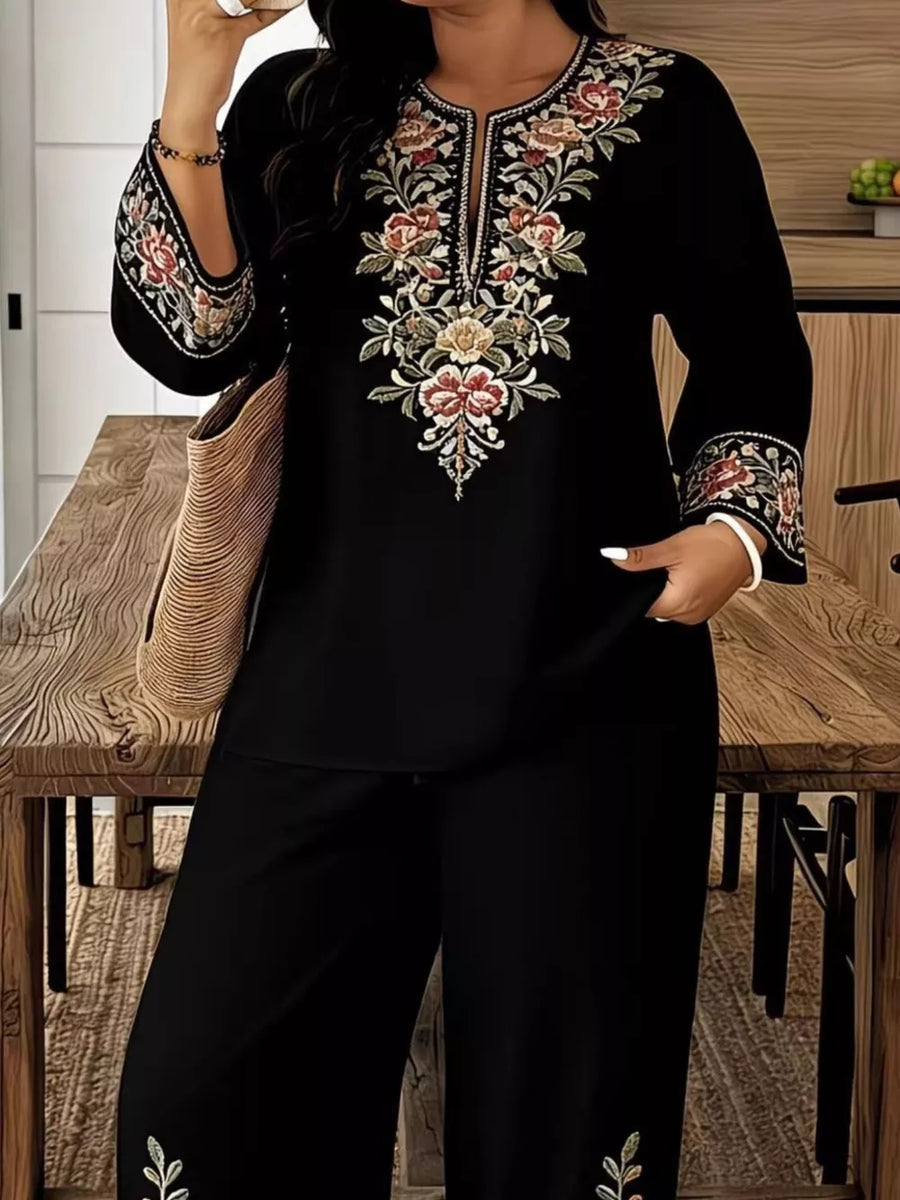 Black embroidered top with floral detail and matching wide-leg pants.