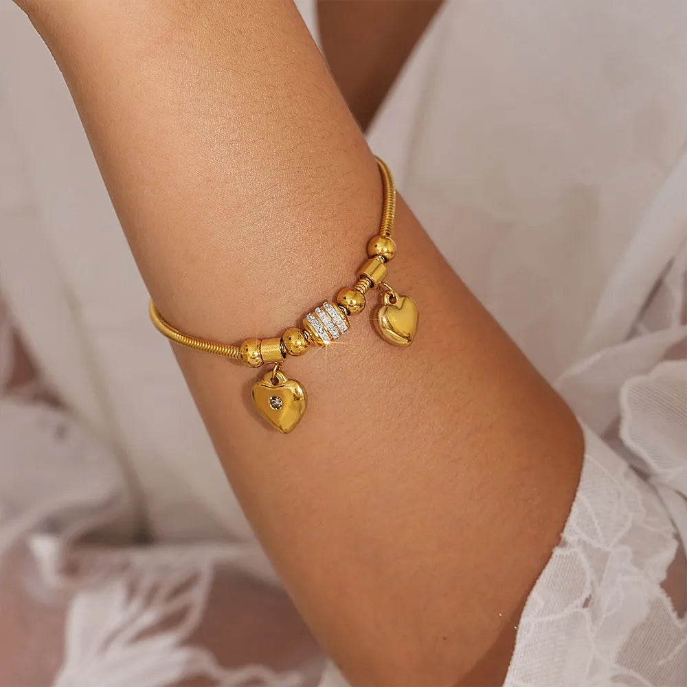 Gold charm bracelet with heart pendants and crystal accents
