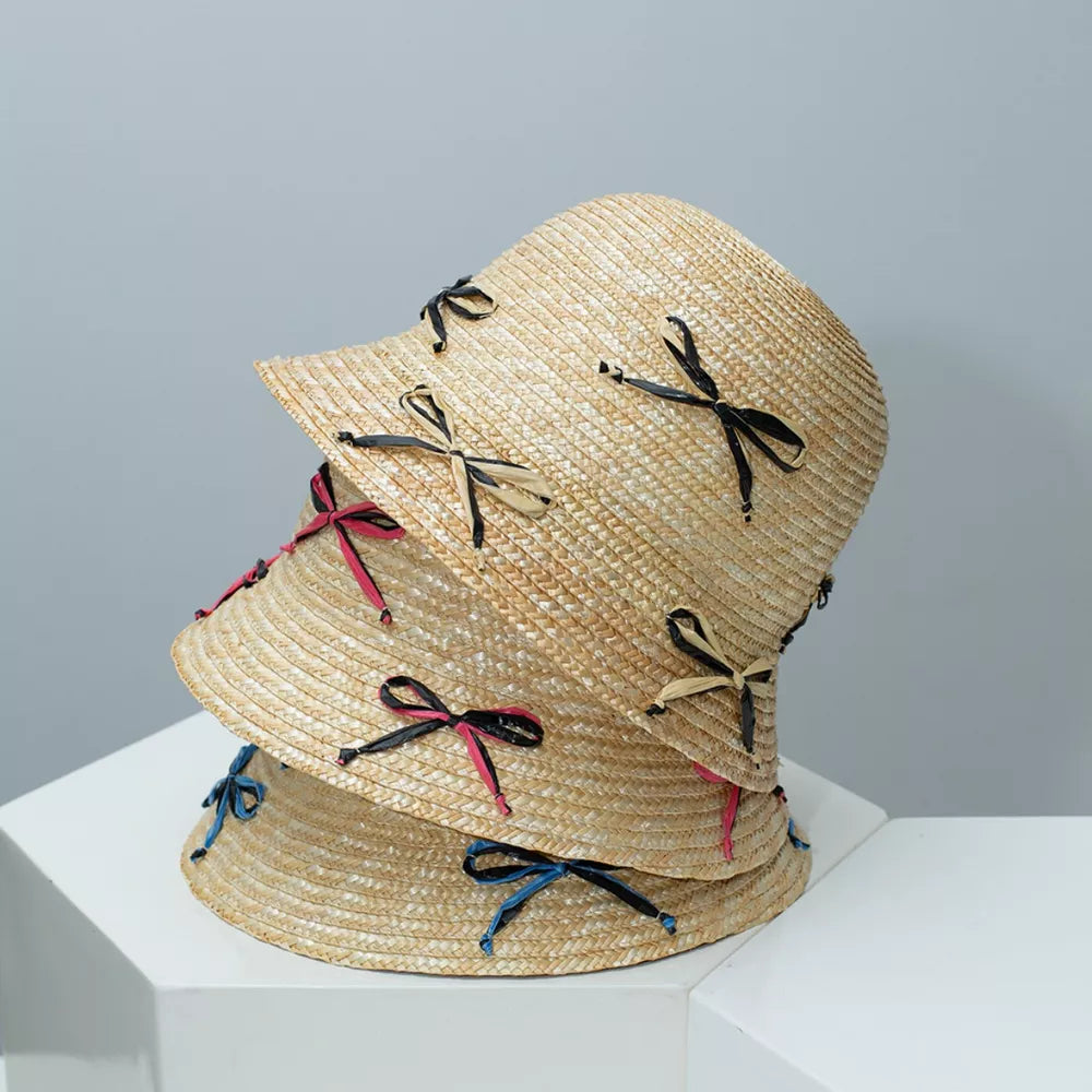 Woven bucket hat with bowknot details in black, blue, and rose red.