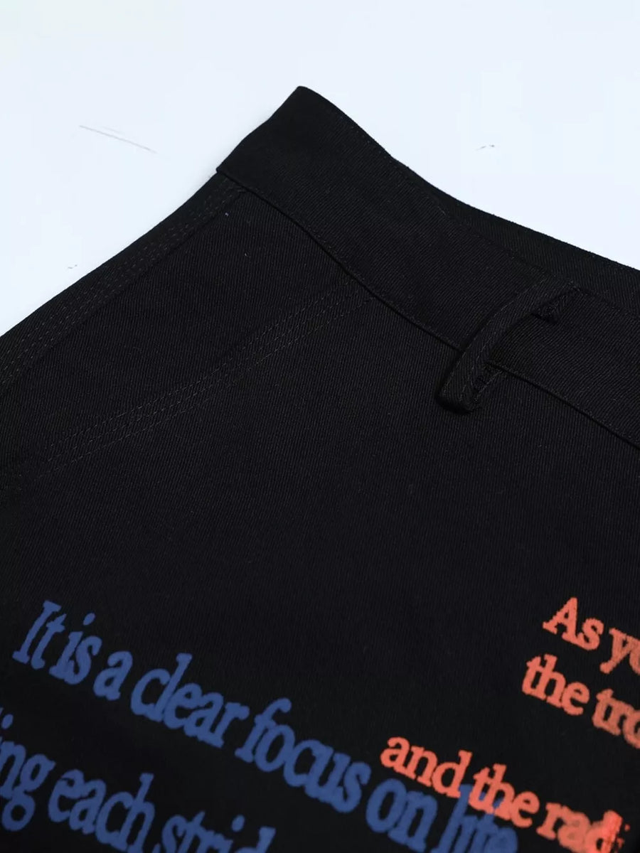 Black cargo pants with blue and orange text print detail